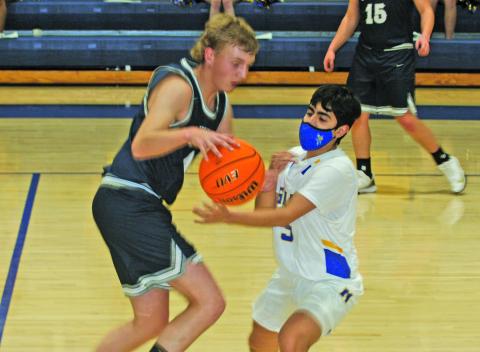 Highlands guard Jeffrey Olvera (5) knocks the ball away from Nantahala guard Zac Taylor during their game in Highlands on Monday night. The Highlanders earned a 72-39 victory.