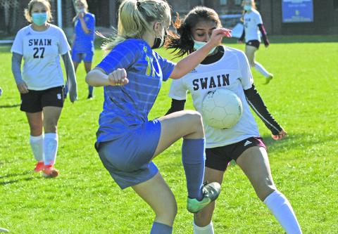Highlands’ Kaitlyn Doerter (11) takes the ball away from a Swain forward.
