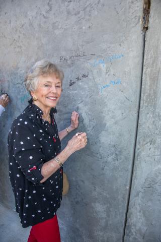 Jane Webb, PAC secretary, signs the wall.