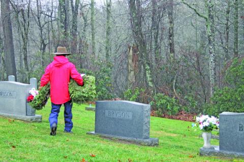 Photo by Christopher Lugo/Staff A volunteer takes wreaths to be placed on veterans’ headstones. 