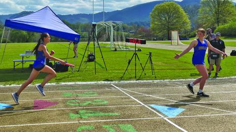 Photo by Jody Pierson/Staff Highlands’ Margaret Cole hands off the baton to teammate Nicole Taylor during the Tri-State Middle School Track Championship at Rabun Gap on Saturday. Highlands and Tallulah Falls battled back and forth to the final event in the team competition.
