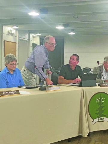 Commissioner Buz Dotson talks with Commissioner Eric Pierson during their meeting last Thursday night. 