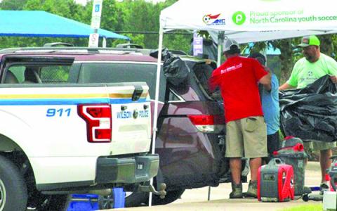 Photo by The Wilson Times A Honda Odyssey van is vacuumed after gunfire shattered its back window at the Gillette Athletic Complex in Wilson, NC.