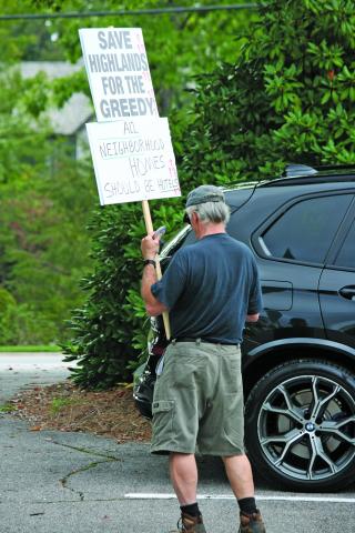 An advocate for eliminating short term rental units in residential zones carries a homemade sign outside a public hearing on Thursday, Aug. 25.