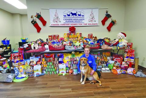 CHHS assistant manager Jodi Henkel plays with one of the shelter’s resident pups in front of the “Stuff the Stockings” donation table. Donations will ensure that the animals at CHHS have a merry Christmas.