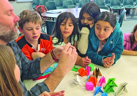 The Bascom’s Billy Love teaches origami to students at The Literacy and Learning Center as part of the after school program.