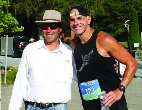  Highlands Twilight 5k organizer Derek Taylor greets race winner Ben Kassel, of Davidson, North Carolina, who set a new course record on Saturday night.