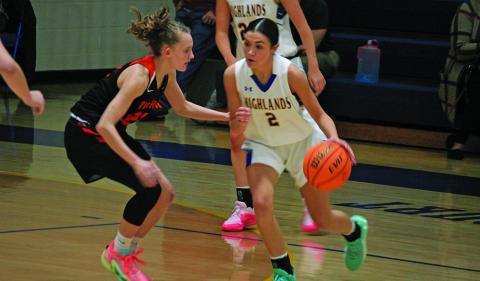 Highlands’ Aislynn Wyatt-Luck (2) tries to drive around a Rosman defender on Friday.