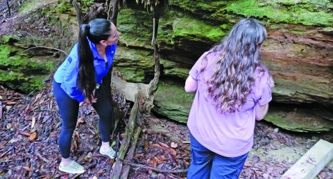 Researcher Reagan Jarrett and Dr. Rada Petric examine a rocky area to see if there are any bats present.