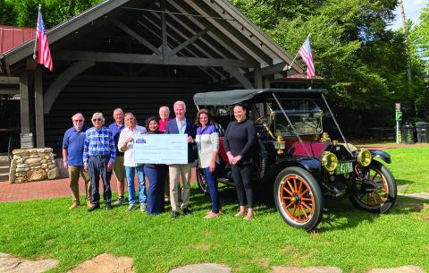 Pictured are Craig Nixon, Steve Ham, Lester Norris, Ricky Siegel, Faviola Olvera, Steve Mehder, David Moore, Cindy Trevathan, and Bonnie Potts. The vehicle is an original 1913 Buick owned by David and Amy Noznesky. 