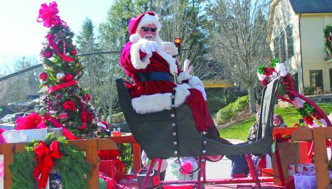 Santa Claus himself gives a shoutout to some young revelers during the Highlands Christmas Parade on Saturday.