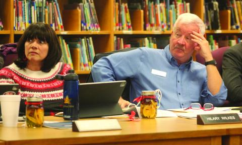 Macon County School Board members Jim Breedlove and Hilary Wilkes listen to a presentation regarding an issue with the heating system at Highlands School.