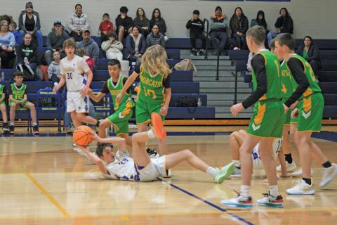 Highlands’ Charlie Wilkes (23) looks for an open teammate while sitting on his backside.