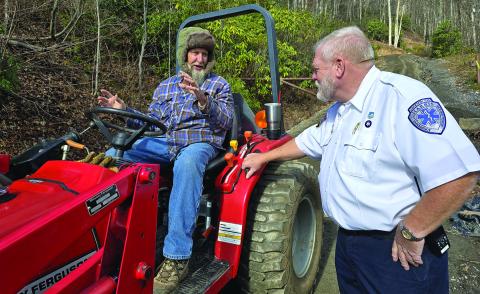 Toby Moore, EMT-P and EMS Supervisor at Harris Regional Hospital, visits with a local Army veteran working his land as they delivered Christmas boxes to seniors in Jackson County.