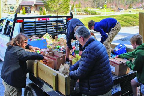 Volunteers with Fishes and Loaves Food Pantry in Cashiers unload a truck filled with donated items following Hurricane Helene.