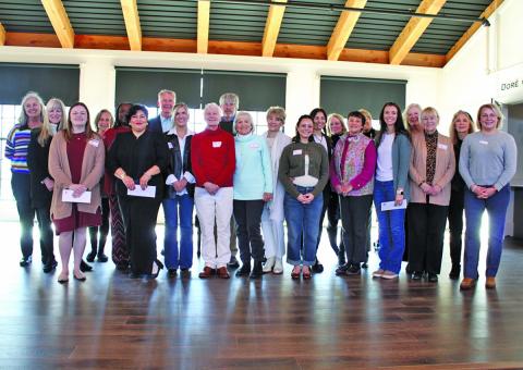 Members of Cashiers Cares gathered on the stage at The Village Green prior to a grant award ceremony last week.