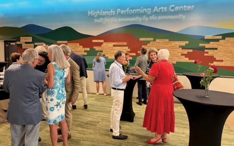 Prominent community members gather at the performing arts center in celebration of its accomplishments.