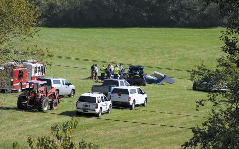 Emergency personnel respond to a plane crash Thursday afternoon in a field west of Iotla Valley Elementary School. The three people aboard will killed.