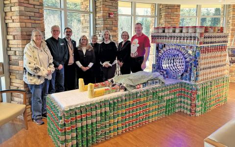 Highlands-Cashiers Hospital created a life-size CT scanner for the fifth annual Healthy Food for Healthier Tomorrow Food and Nutrition Drive. Pictured here are Marie Johnson, Highlands Emergency Council; Larry Morris, Fishes and Loaves; Tom Neal, CEO/CNO Highlands-Cashiers Hospital; construction volunteers Robin Neal & Betsy Carson; Bonnie Dayton, Highlands Food Pantry; designer Cath Connolly Hudson; and Andy Eidson, Highlands Emergency Council.  |  Photo courtesy of Highlands-Cashiers Hospital