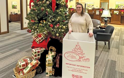 Regions Bank branch manager Jessica Farrell stands amongst donated gifts for the Macon County Elves toy donation program at the Highlands Regions Bank location.