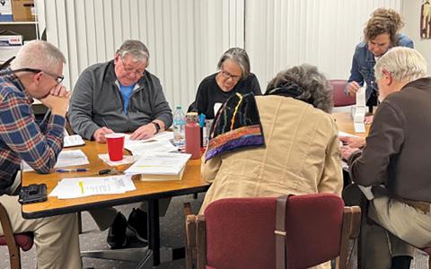 The Macon County Board of Elections members and Board of Elections Supervisor Melanie Thibault (standing) during Early Voting counting on March 3. Board members are (from left) Chair John Vanhook, Gary Dills, Kathy Tinsley, Paul Niskanen and Lynne Garrison.  |  Photo by Mia Overton/Staff