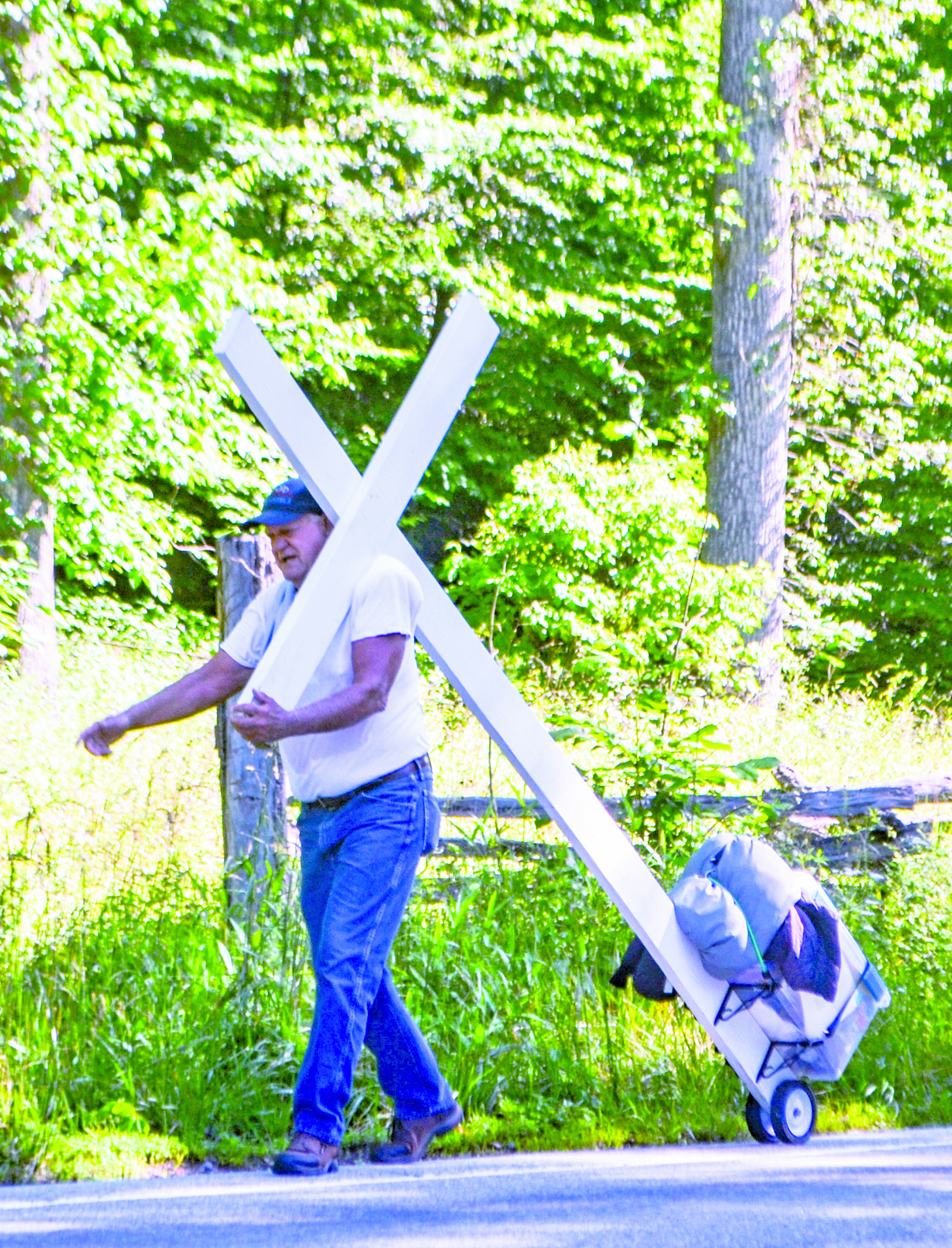 Roger Gates is walking across the United States pulling a cross to raise money to stock a food and medical supply warehouse for people in need. He stayed in Highlands on June 22 before heading toward Franklin.