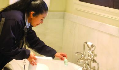 Sandra Valero, housekeeping supervisor with Old Edwards Inn separates single-use plastic shampoo and conditioner bottles for recycling.