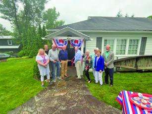 Highlands Historical Society president Obie Oakley cuts the ribbon surrounded by board members and Highlands mayor Patrick Taylor. 