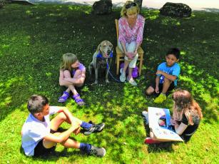 Submitted Photo Children reading outside during last year’s summer camp at The Literacy and Learning Center. 