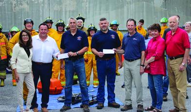 Representatives from Highlands Festivals Inc. and Sky Valley-Scaly Mountain Fire and Rescue gathered to exchange a $20,000 donation check that will help the department buy a new truck.