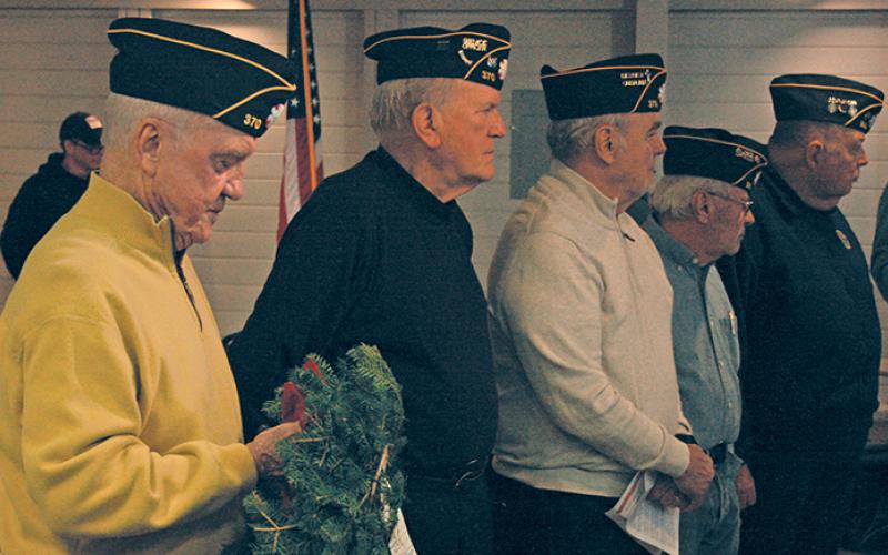 Members of American Legion Post 370 wait their turn to place memorial wreaths in honor of each branch of the United States military.