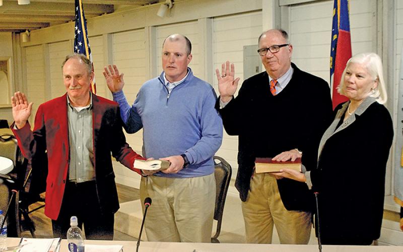 John “Buz” Dotson, Brian Stiehler and Marc Hehn, with the family Bible held by his wife Betsy, are sworn in as commissioners during the Dec. 12 meeting.