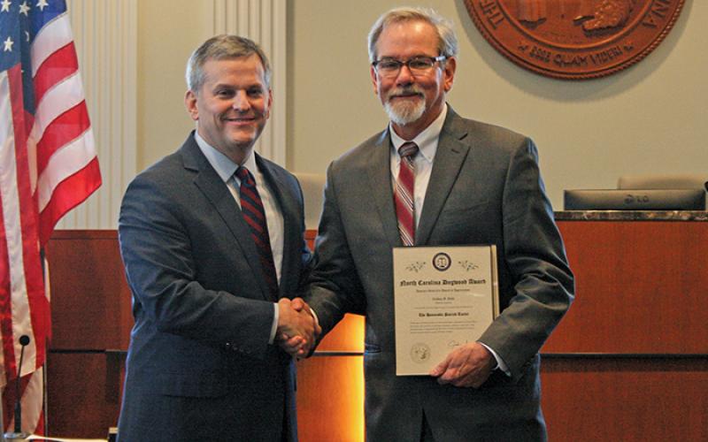 NC Attorney General Josh Stein gives mayor Patrick Taylor the 2019 Dogwood Award.