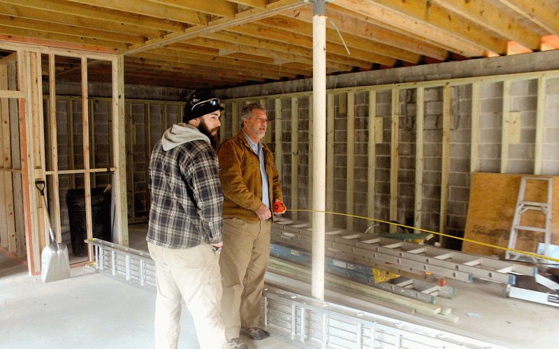 Ray Davis, of Northeast Georgia Heating and Air takes measurements of the potential retail space in a building being renovated on Fifth Street in downtown highlands.