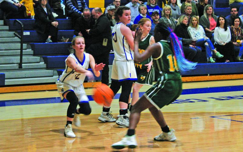 Highlands’ Hayley Borino (12) comes over a Kedra McCall (40) screen and  makes an entry pass to the post while Bessemer City’s Kiayzia Degree (10) defends during their NCHSAA 1-A State Playoff game on Tuesday night.