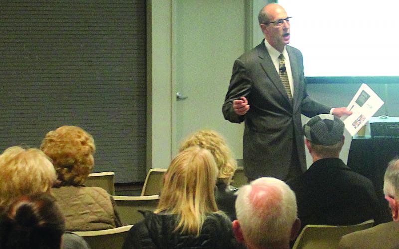 Gibbins Advisors Managing Director Tom Urban speaks to a crowd during a public forum in Highlands.