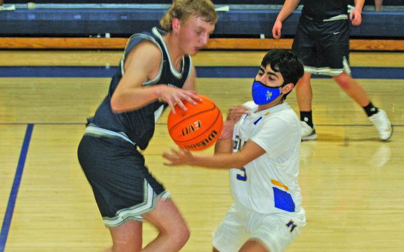 Highlands guard Jeffrey Olvera (5) knocks the ball away from Nantahala guard Zac Taylor during their game in Highlands on Monday night. The Highlanders earned a 72-39 victory.