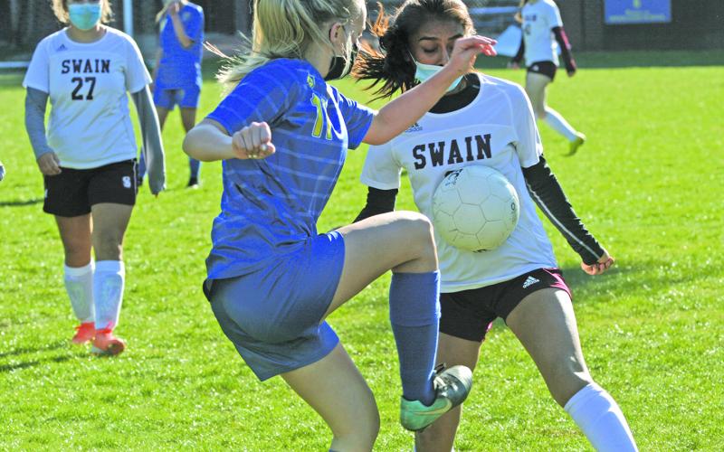 Highlands’ Kaitlyn Doerter (11) takes the ball away from a Swain forward.