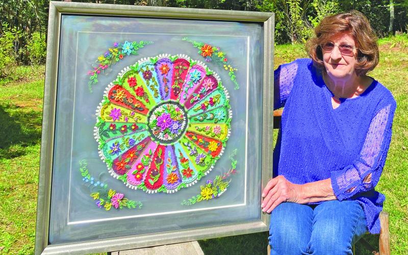 Local fiber artist Betty Cabe displays one of her quilling works prior to an exhibition.