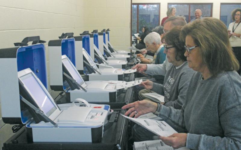 Election workers test equipment during a simulation.