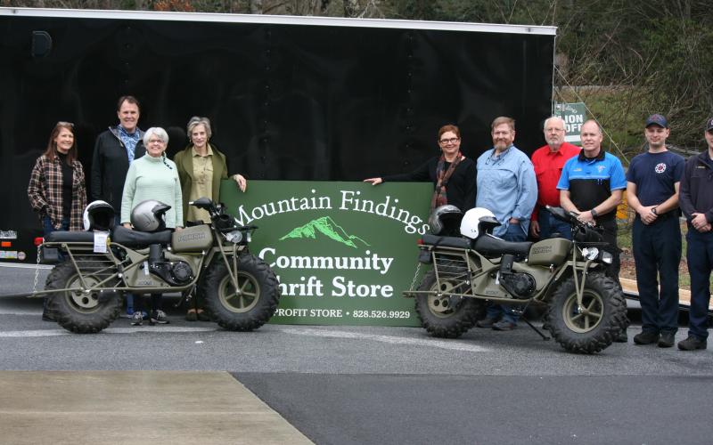 Photo by Ryan Hanchett/Staff Mountain Findings board members Jill Helmer, Steve Parnell, Steve Mehder, Delaine Mehder, John Warner, Amy Cooper and Beth Townes presented two new rescue motorcycles, safety equipment and a trailer to Todd Doster with Macon County EMS and members of Macon County Squad 4 fire and rescue. Not pictured are board members Lou Rosebrock and Dan Rupp.