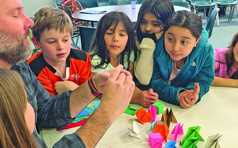 The Bascom’s Billy Love teaches origami to students at The Literacy and Learning Center as part of the after school program.