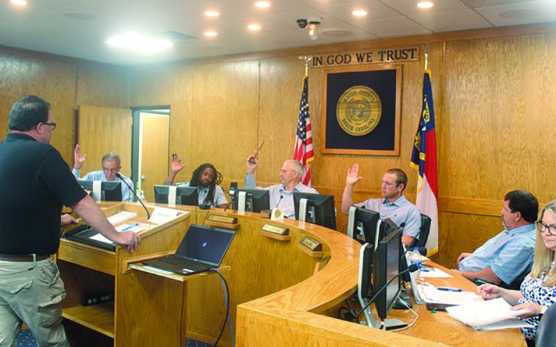 Commissioners Gary Shields, Danny Antoine, Paul Higdon and Josh Young vote for solid waste fee hikes during a special called meeting on Monday. Commissioner John Shearl, sitting next to Young, voted against the fee increases. Also pictured is Solid Waste Director Chris Stahl and Finance Director Lori Carpenter.