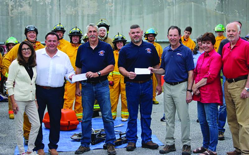 Representatives from Highlands Festivals Inc. and Sky Valley-Scaly Mountain Fire and Rescue gathered to exchange a $20,000 donation check that will help the department buy a new truck.
